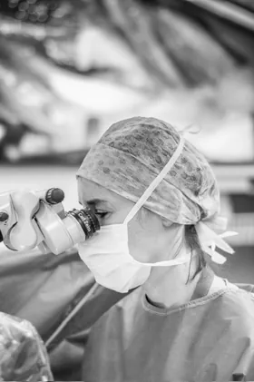 Le Dr Charlotte Waxweiler opérant au microscope chirurgical