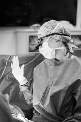 Le Dr Charlotte Waxweiler au bloc opératoire, main gantée levée